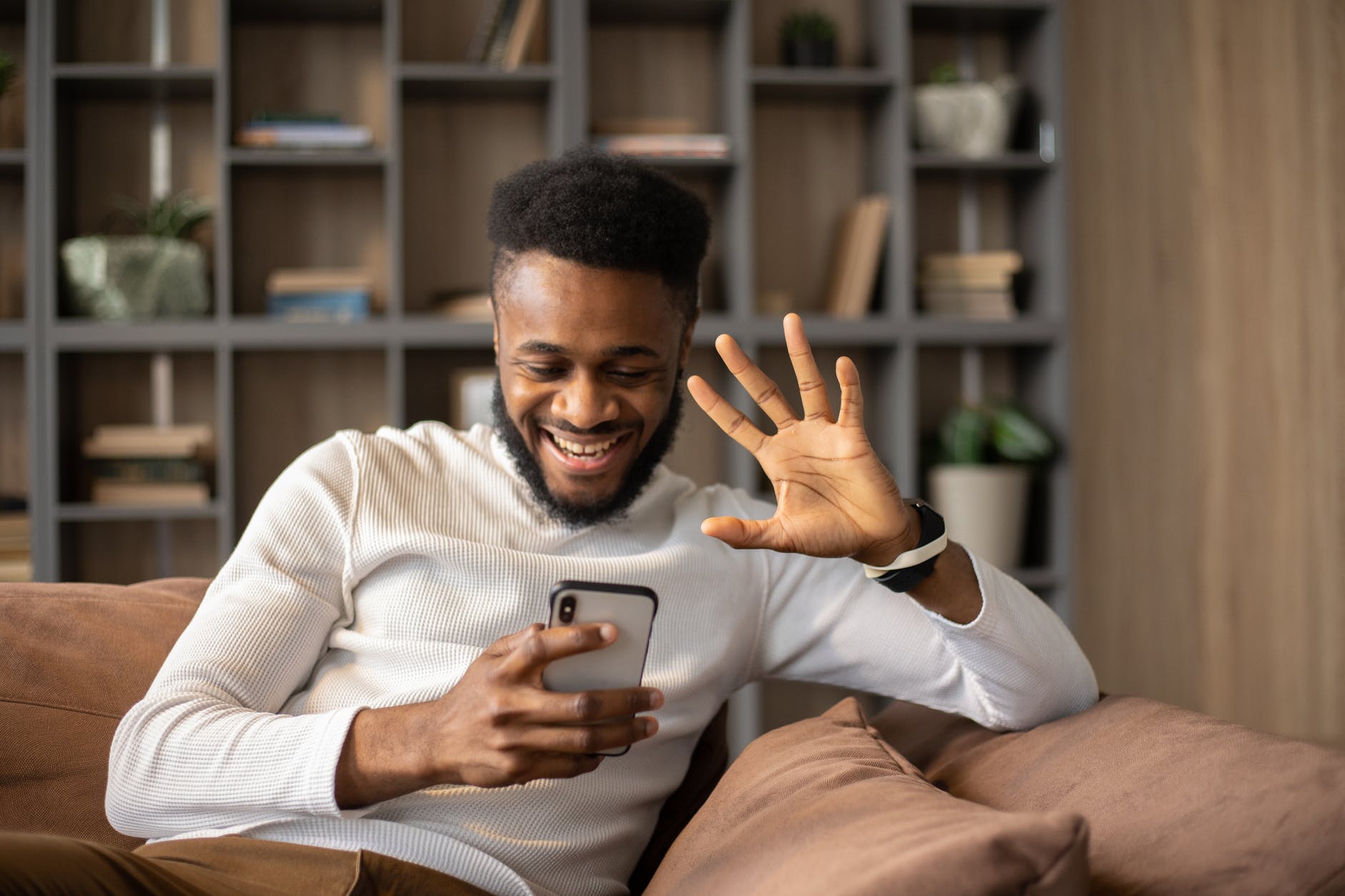 cheerful black man having video call and waving hand